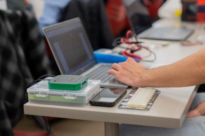 A close up of a student working on their laptop with the AD3 set up next to it.