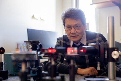 Ting-Chung Poon examines a holographic set up in his lab. Photo by Ben Murphy for Virginia Tech.