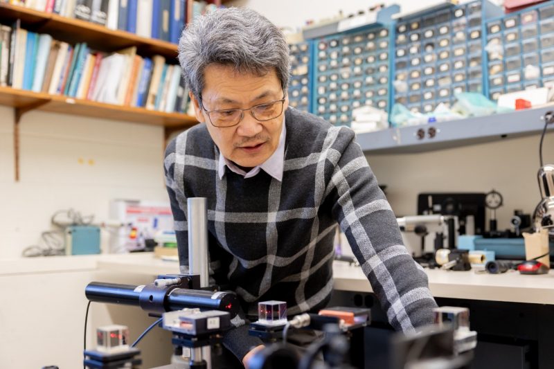 T.-C. Poon sets up a holographic display in his lab. Photo by Ben Murphy for Virginia Tech.