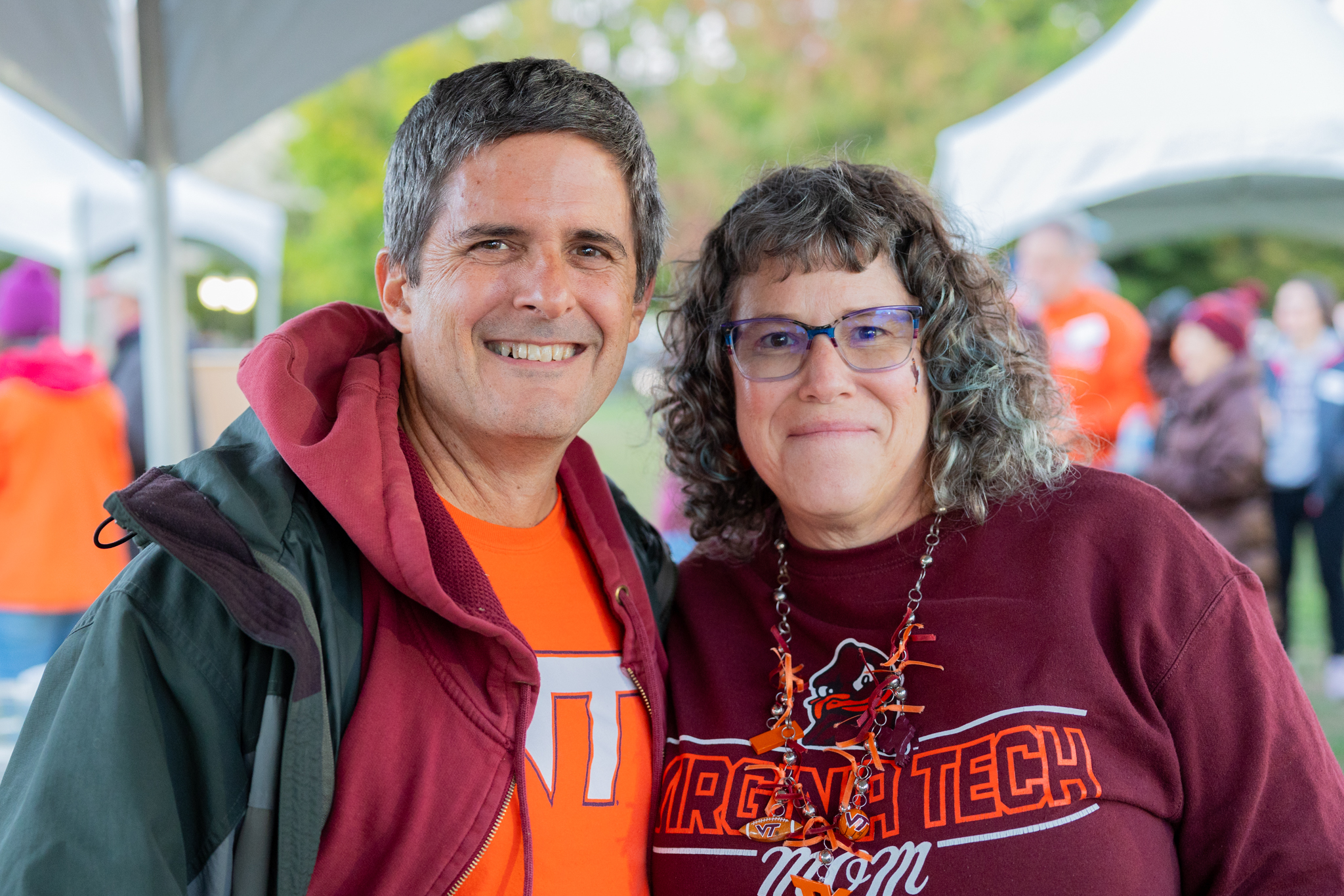 Two Virginia Tech ECE alumni smile at a tailgate.