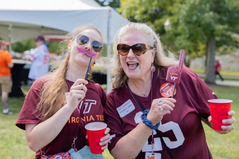 Two ECE alumni smile and pose at a tailgate!