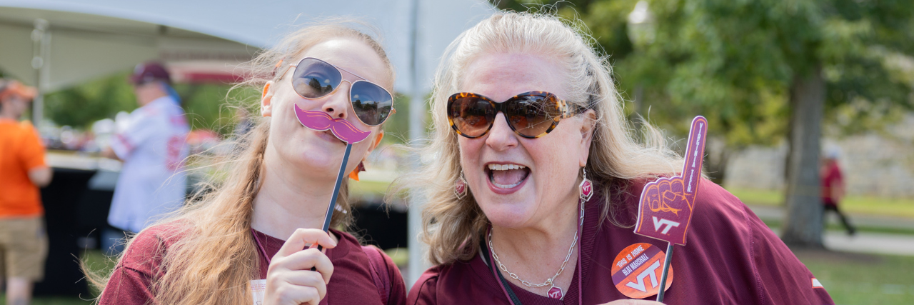 Two ECE alumni smile and pose at a tailgate!