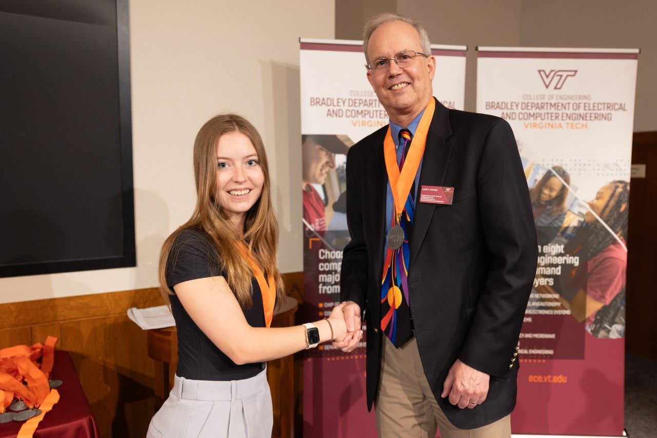 From left: ECE alum Carly Liesegang shakes hands with former department head Luke Lester.