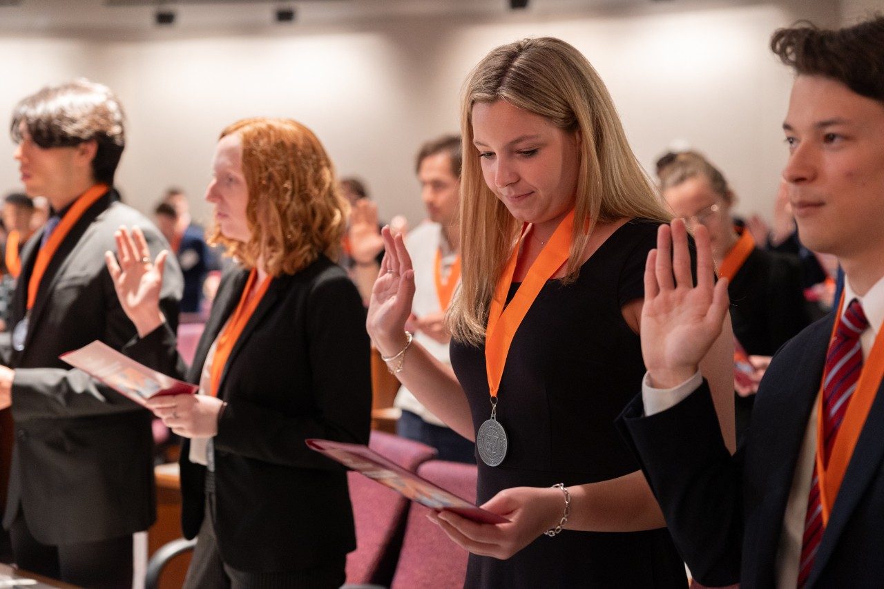 ECE alum Claire Doody raises her hand during the Heta Lambda Beta (HLB) ceremony.