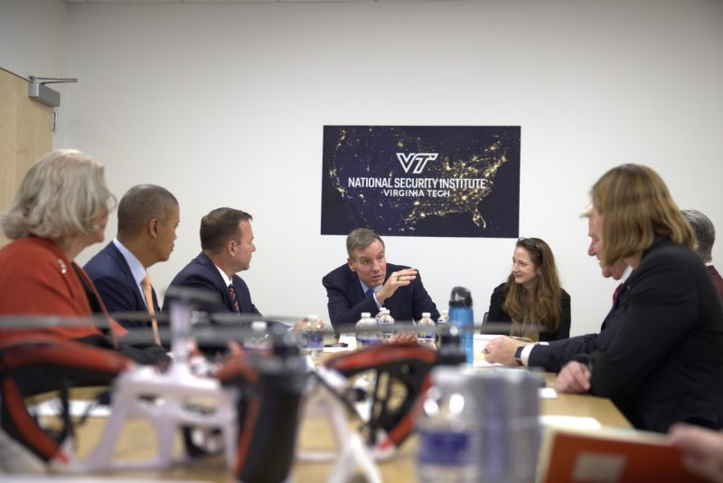 People sitting at board room table.