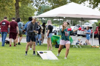 Two people playing cornhole outside of the Virginia-Maryland College of Vet Med