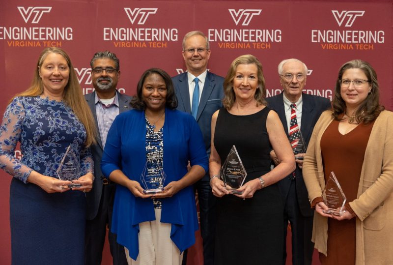 ECE Distinguished Alumni in front of backdrop with awards