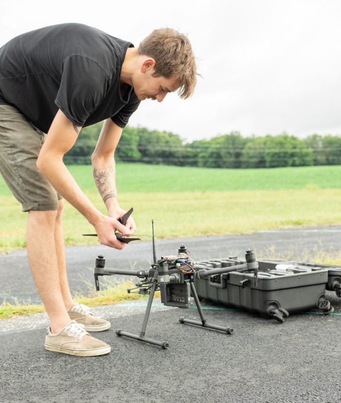 Student works on drone in a field